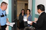 Senior Police Officer M.D. Prause and Councilmember Al Hoang offer safety advice to two Happy Village Apartment residents