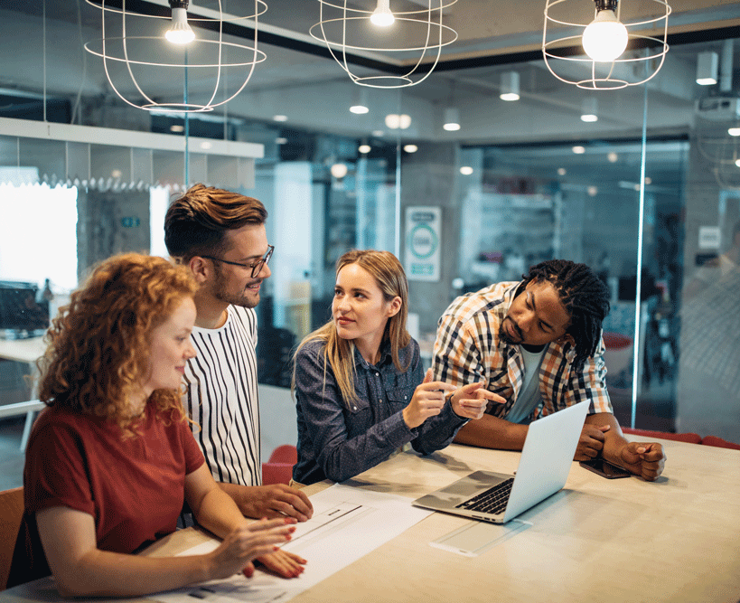 People in office talking in front of computer