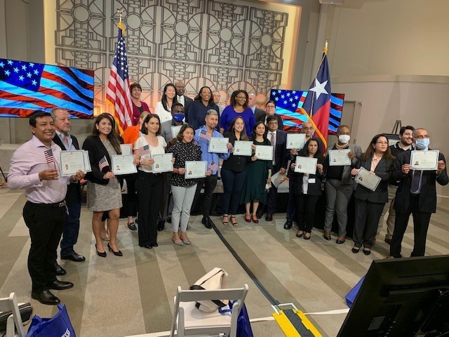 New Americans pose, holding their U.S. Citizenship certificates.